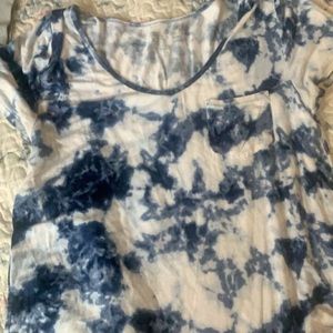 A tie dye blue and white v neck shirt